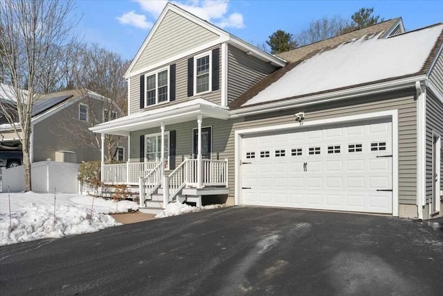 traditional home with covered porch, driveway, an attached garage, and fence