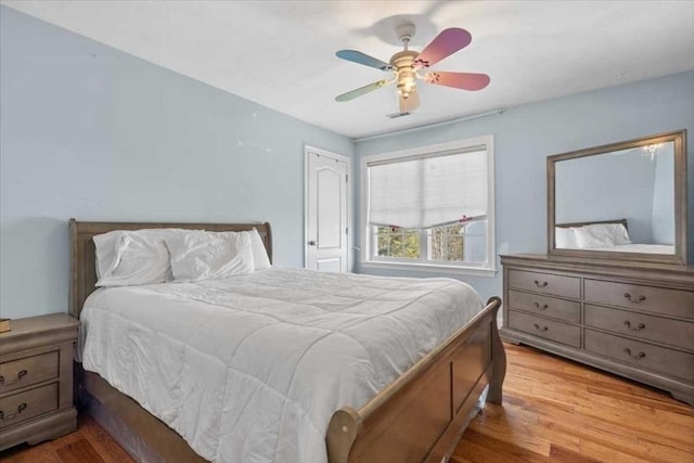 bedroom with visible vents, ceiling fan, and wood finished floors