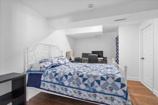 bedroom with visible vents and wood finished floors