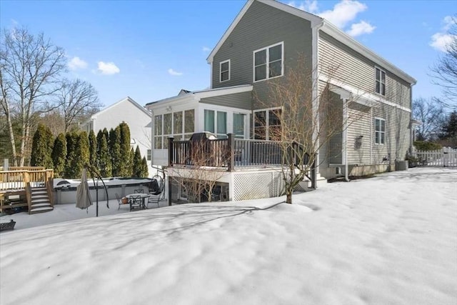 snow covered property with a sunroom, central AC, a deck, and a fenced in pool