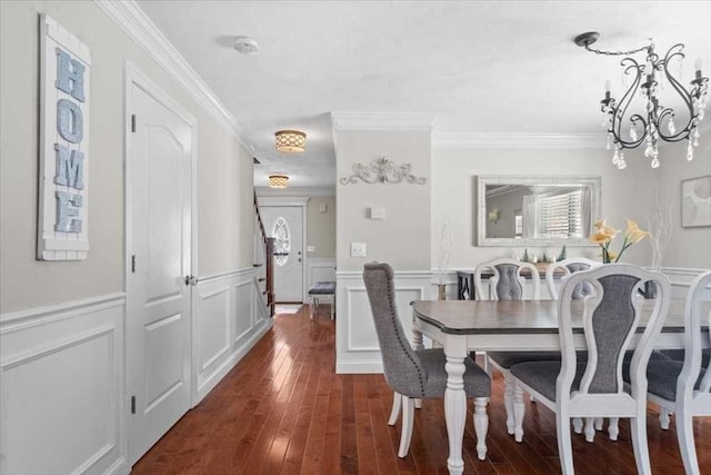 dining room with dark wood-type flooring, a healthy amount of sunlight, crown molding, and a notable chandelier