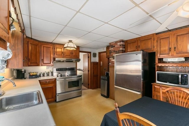72 Heath St, Tewksbury, MA 01876 - kitchen featuring appliances with stainless steel finishes, a sink, light countertops, under cabinet range hood, and a drop ceiling