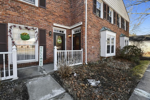 entrance to property featuring brick siding