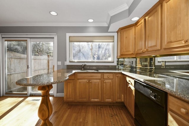 kitchen featuring dishwasher, wood finished floors, a wealth of natural light, and a sink