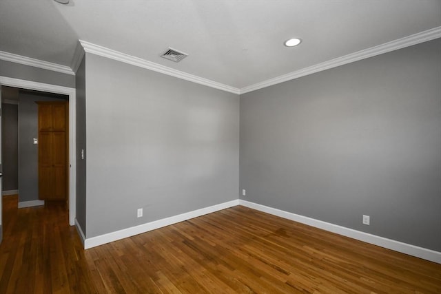 unfurnished room featuring visible vents, baseboards, wood finished floors, and crown molding