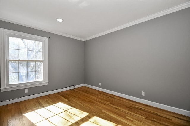 unfurnished room with wood finished floors, baseboards, ornamental molding, and recessed lighting