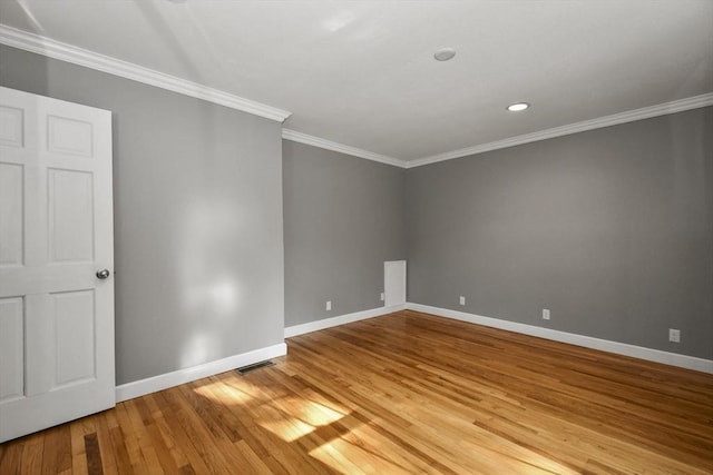 empty room with visible vents, light wood-style flooring, baseboards, and ornamental molding