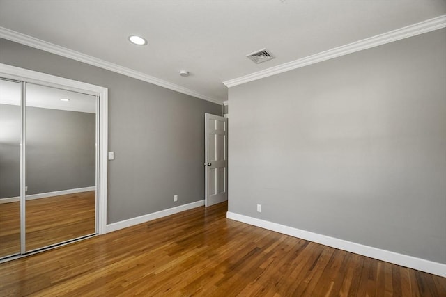 unfurnished bedroom featuring visible vents, ornamental molding, wood finished floors, recessed lighting, and baseboards