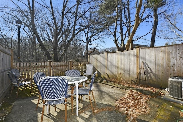 view of patio / terrace with outdoor dining space, central air condition unit, and a fenced backyard