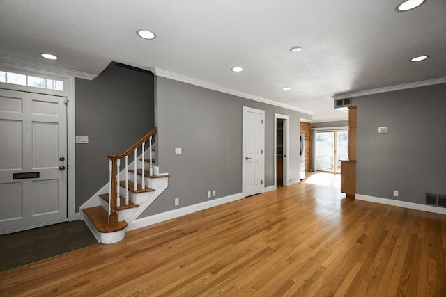 interior space featuring visible vents, wood finished floors, stairs, and crown molding