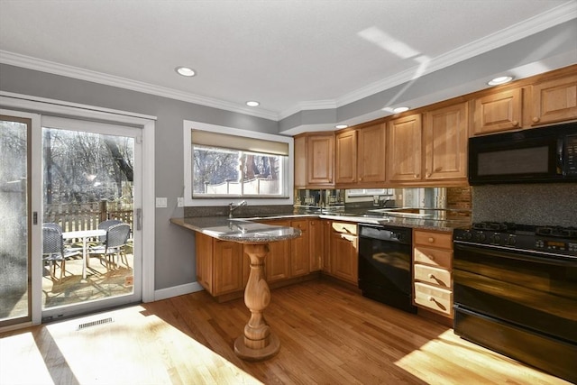 kitchen with visible vents, a healthy amount of sunlight, black appliances, and light wood-style floors