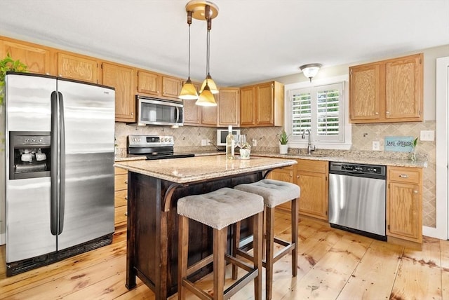27 Lakeview St, Southwick, MA 01077 - kitchen with a center island, decorative backsplash, stainless steel appliances, and light wood-type flooring