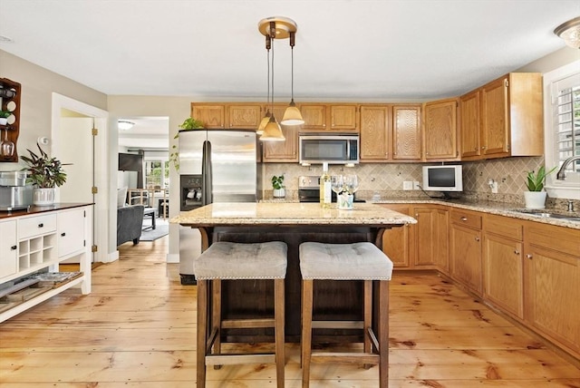 27 Lakeview St, Southwick, MA 01077 - kitchen with decorative backsplash, a kitchen breakfast bar, a center island, a sink, and stainless steel appliances