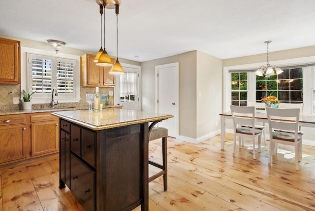 27 Lakeview St, Southwick, MA 01077 - kitchen with tasteful backsplash, a sink, light wood-style flooring, a center island, and a kitchen bar