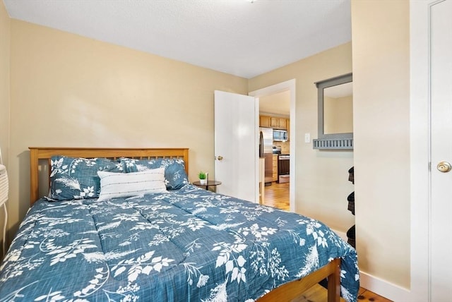 27 Lakeview St, Southwick, MA 01077 - bedroom featuring freestanding refrigerator and wood finished floors