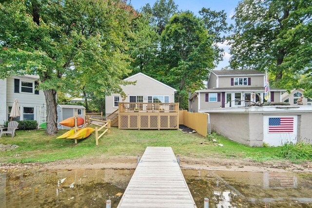 27 Lakeview St, Southwick, MA 01077 - rear view of house featuring a deck, an outbuilding, fence, a storage unit, and a yard