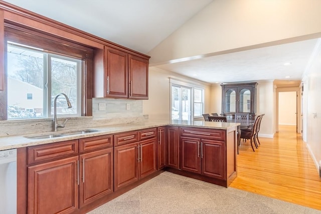 kitchen with sink, dishwasher, tasteful backsplash, vaulted ceiling, and kitchen peninsula