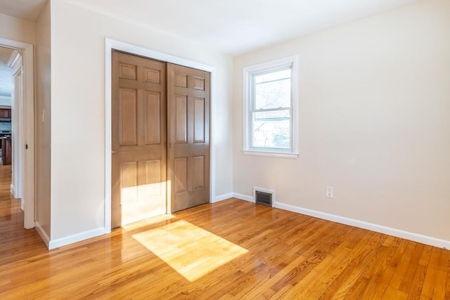 unfurnished bedroom featuring light hardwood / wood-style floors and a closet