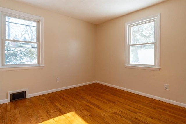 spare room featuring hardwood / wood-style flooring and a healthy amount of sunlight