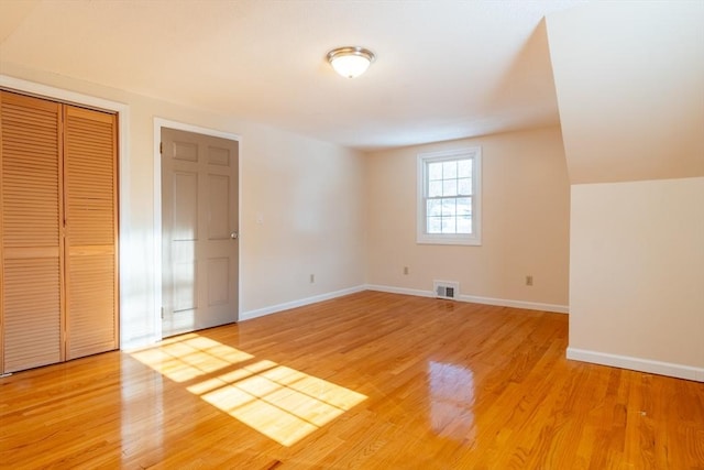 unfurnished bedroom with light hardwood / wood-style floors and a closet