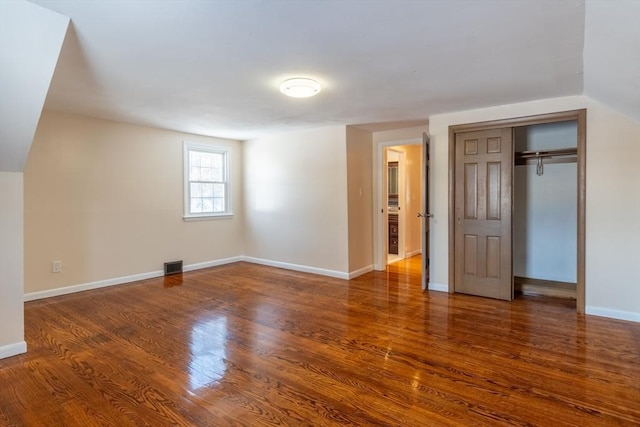 unfurnished bedroom featuring dark wood-type flooring and a closet