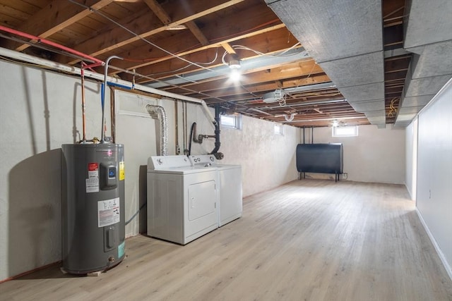 basement with separate washer and dryer, hardwood / wood-style flooring, and water heater