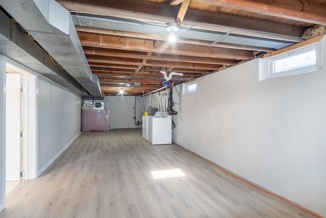 basement with washer / dryer and light hardwood / wood-style floors