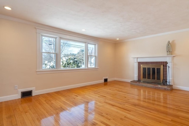 unfurnished living room with light hardwood / wood-style flooring, crown molding, and a fireplace