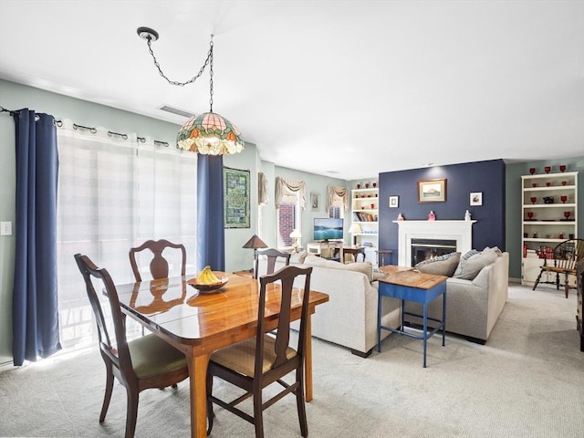 dining room featuring light carpet and built in features