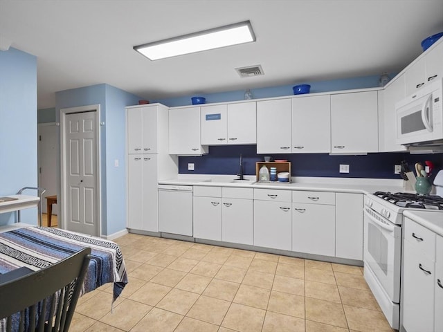 kitchen featuring white appliances, white cabinetry, sink, and light tile patterned flooring