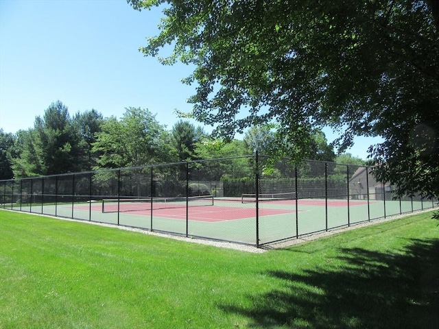 view of tennis court with a yard