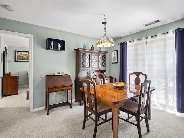 dining area featuring light carpet