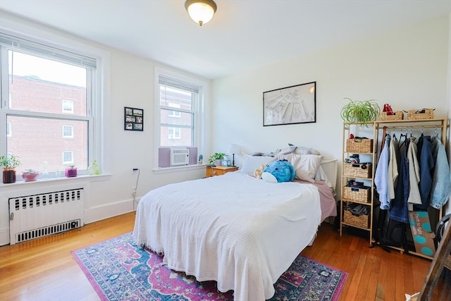 33 Saint Paul St Unit 3, Brookline, MA 02446 - bedroom featuring radiator heating unit, cooling unit, and wood finished floors