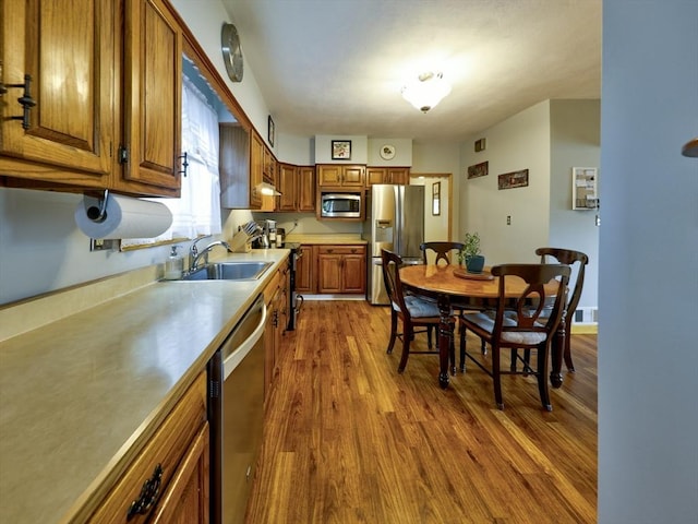 27 Newton Ave, Lynn, MA 01905 - kitchen featuring stainless steel appliances, brown cabinets, dark wood finished floors, and light countertops