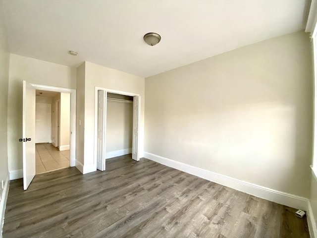 unfurnished bedroom featuring hardwood / wood-style flooring and a closet