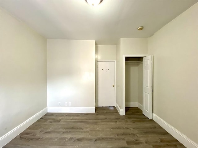 unfurnished bedroom with hardwood / wood-style flooring and a closet