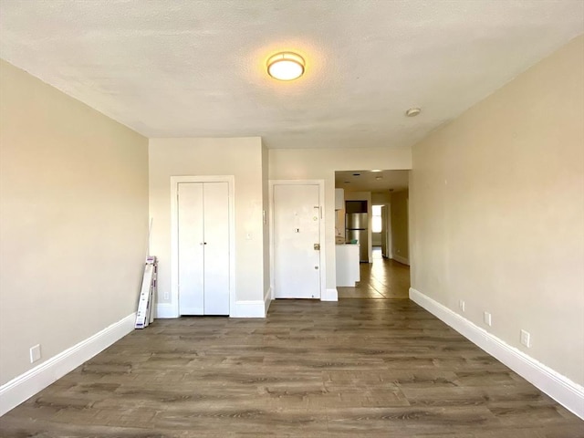 spare room with dark wood-type flooring and a textured ceiling