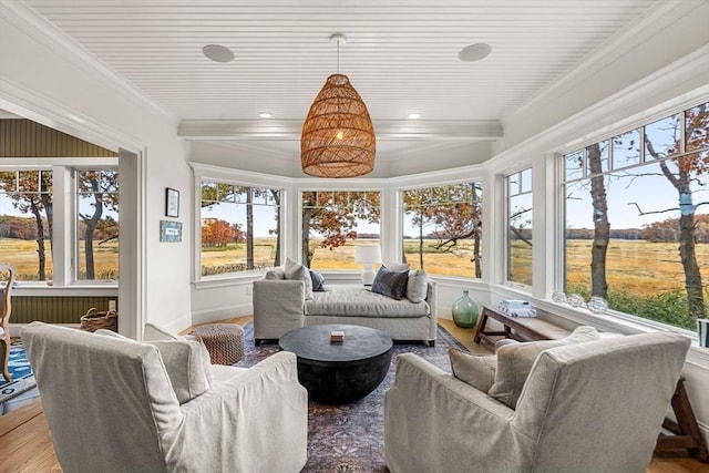 sunroom / solarium with crown molding, baseboards, plenty of natural light, and wood finished floors