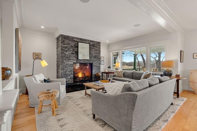 living area featuring light wood finished floors, a fireplace, recessed lighting, baseboards, and ornamental molding