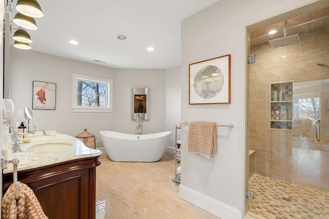 full bathroom with vanity, recessed lighting, a freestanding tub, a shower stall, and visible vents