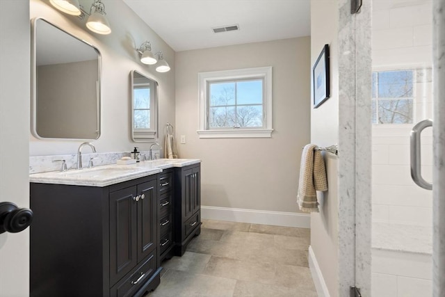 full bath with visible vents, a sink, baseboards, and double vanity