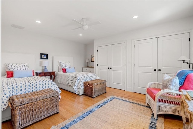 bedroom featuring visible vents, multiple closets, recessed lighting, and light wood finished floors