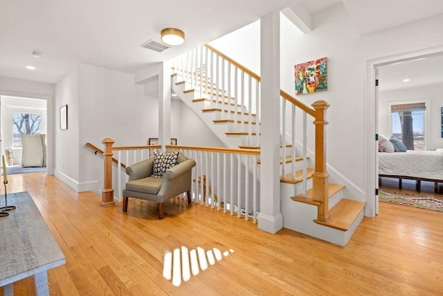 staircase featuring baseboards, recessed lighting, wood finished floors, and visible vents