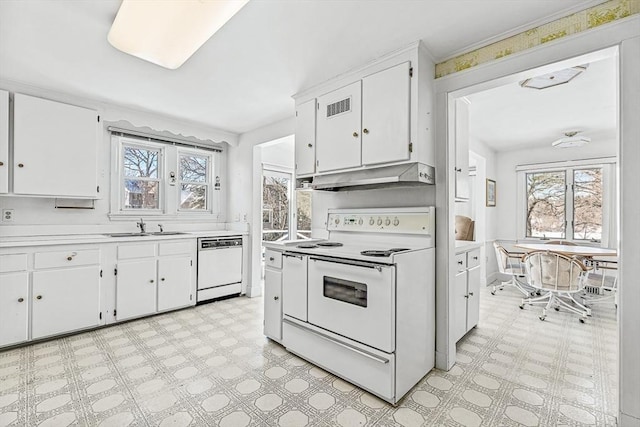 kitchen with sink, white appliances, and white cabinets