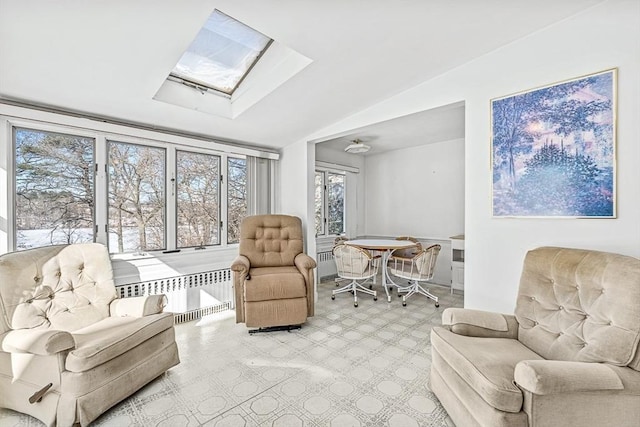 living area featuring radiator and vaulted ceiling with skylight