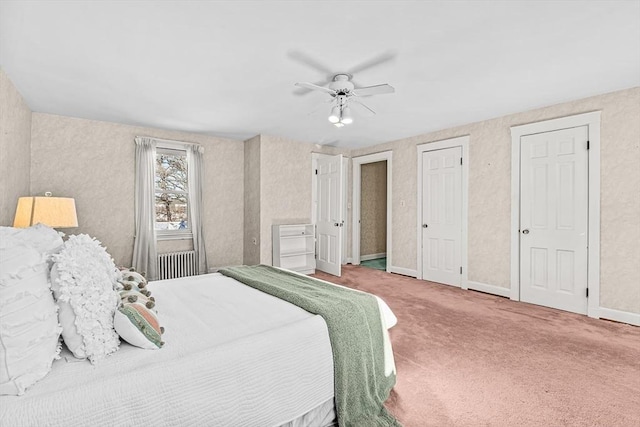 bedroom with ceiling fan, carpet flooring, and two closets