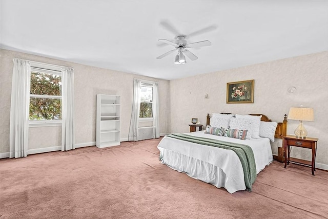 carpeted bedroom with multiple windows, radiator heating unit, and ceiling fan