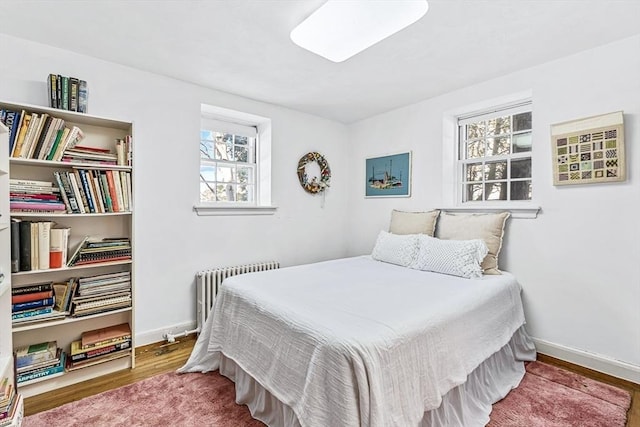 bedroom featuring radiator and hardwood / wood-style floors