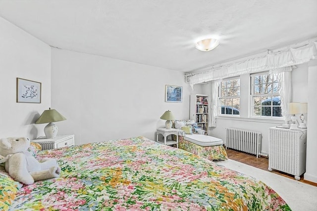 bedroom with hardwood / wood-style floors and radiator heating unit