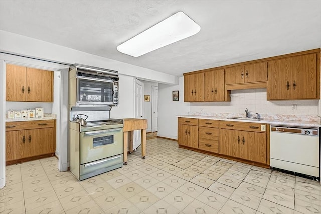 kitchen featuring tasteful backsplash, sink, range with electric cooktop, and dishwasher